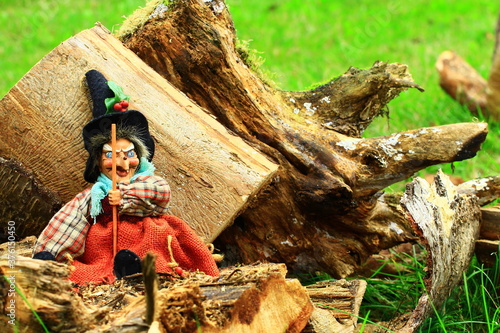Wiedźma czarownica siedząca na kawałku świeżo pociętego drzewa 