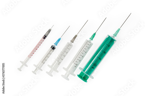 Different disposable syringes with needles on white background, top view