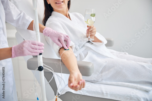 Smiling female patient undergoing intravenous vitamin therapy