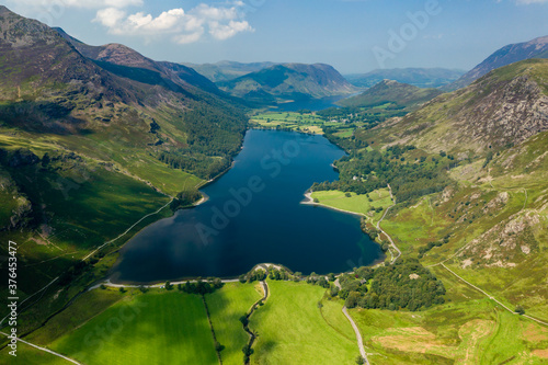 Aerial view of a beautiful lake in a narrow valley surrounded by tall mountains (Buttermere)