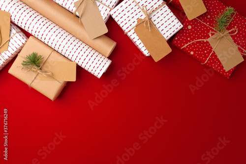 Christmas preparations concept with wrapping paper, gift boxes on red background