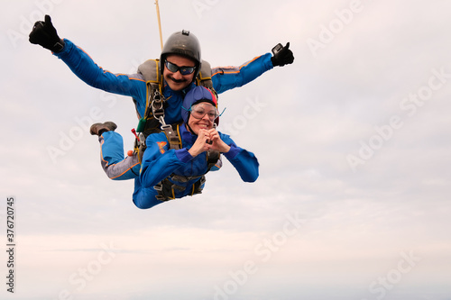 Skydiving. Tandem jump. A girl and her instructor are flying in the sky.