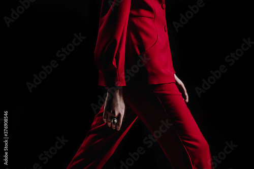 Cropped female fashion model in red stylish classy suit jacket and pants walking runway on the Fashion Show. Close up designer fashion details. Catwalk Fashion Week