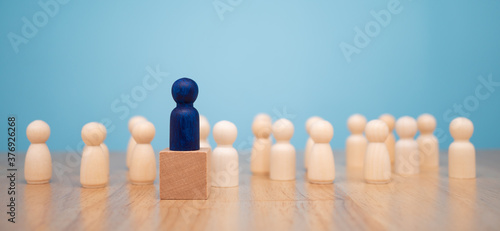 Wooden figure standing on the box for show influence and empowerment. Concept of business leadership for leader team, successful competition winner and Leader with influence