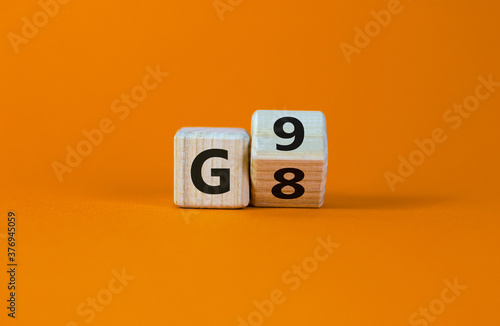 Symbol for the duration of the secondary school in Germany. Expanded wood cube with G8 '8 years' to G9 '9 years' or vice versa on beautiful orange background, copy space. Educational concept.