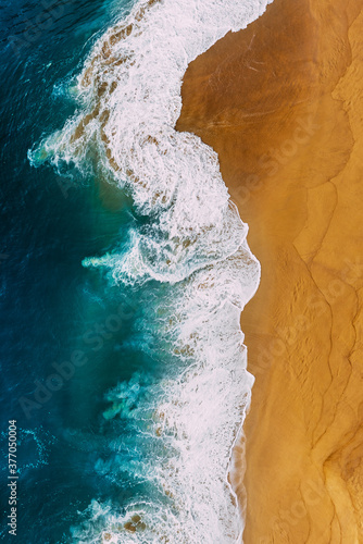Beautiful sea wave. Clean beach with beautiful yellow sand and turquoise sea, vertical photo. Beautiful seascape, view from the height. Beautiful sandy beach, top view. The ocean and beach. Copy space