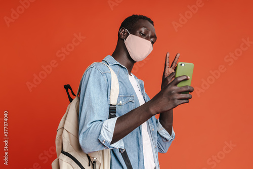 Man wearing a medical mask taking a selfie