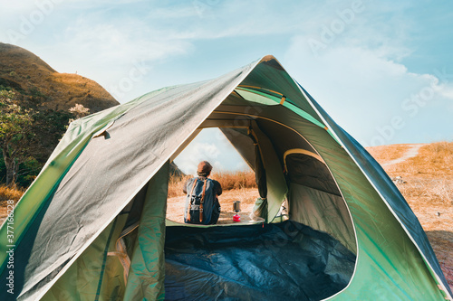 wanderlust and relax in nature with solo hiker man camping on top of mountain on spring and summer season