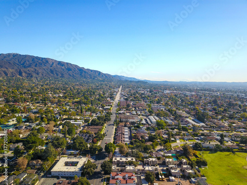 stunning aerial shot of the snow capped mountain ranges and blue skies of Monrovia California with a view of the homes below