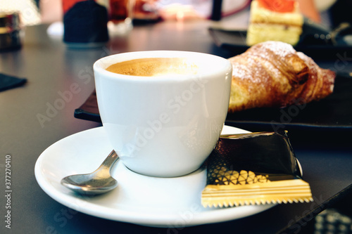 A cup of delicious morning espresso coffee with freshly baked croissant in Trieste, Italy