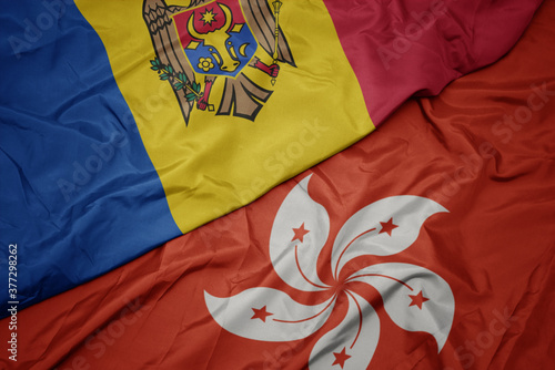 waving colorful flag of hong kong and national flag of moldova.