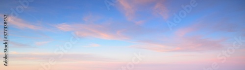 Clear blue sky with glowing pink cirrus and cumulus clouds after storm at sunset. Dramatic cloudscape. Concept art, meteorology, heaven, hope, peace, graphic resources, picturesque panoramic scenery