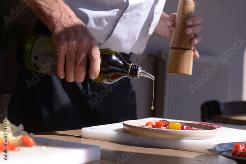 chef cuisinier avec de l'huile d'olive et du poivre