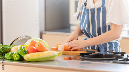 キッチンでにんじんを切る女性