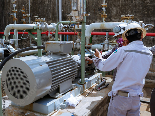 Technician checking and reading data vibration measurement of motor in power plant.