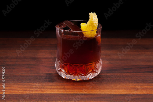 Vieux Carre cocktail with a large rock and lemon peel
