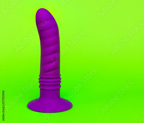 A purple dildo on a green background