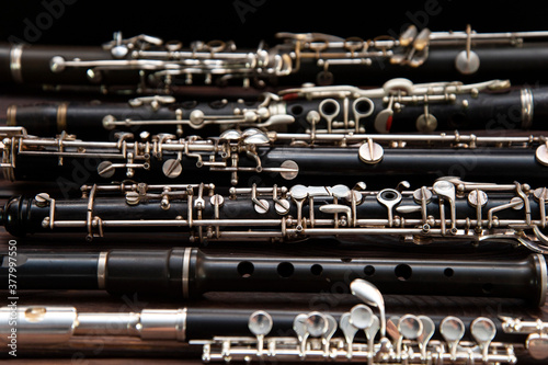 Many woodwind instruments lie on a wooden surface. View from above