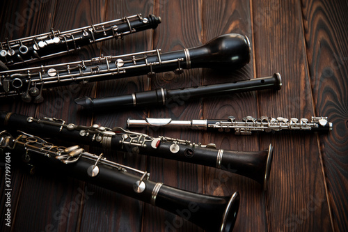 Woodwind instruments lie on a wooden surface