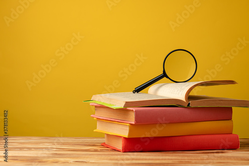 Pile of colorful textbooks on wooden desk