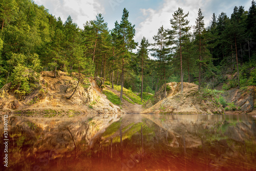 Natural colorful lakes in Europe. Kolorowe Jeziorka in Rudawy Janowickie, Poland. Beautiful purle lake with reflection against forest.