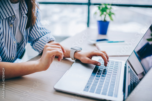 Cropped image of female hands searching web information during social networking via modern laptop computer, woman connecting to wifi wireless for making online netbook booking and banking