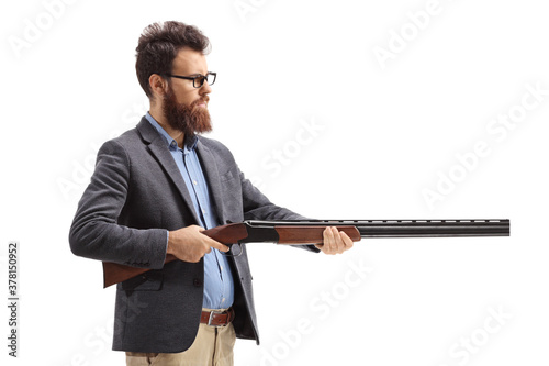 Bearded man aiming with a shotgun