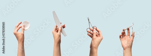 Female hands holding manicure and pedicure tools isolated on blue background with copy space, horizontal banner format. Cotton pads, nail file, scissors and cuticle nippers in human hand