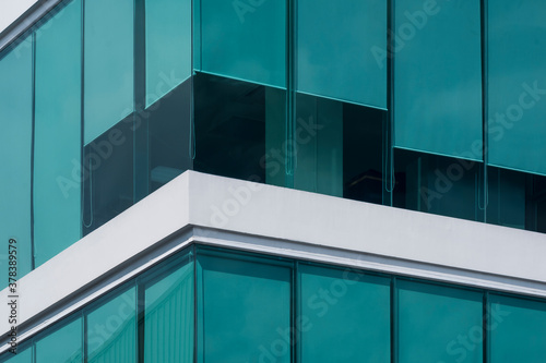 Green roller blinds inside of modern glass office building