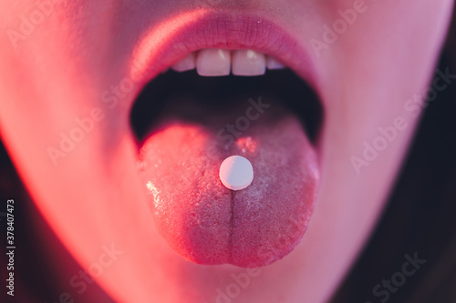 beautiful girl with lsd on tongue in nightclub with pink smoke.