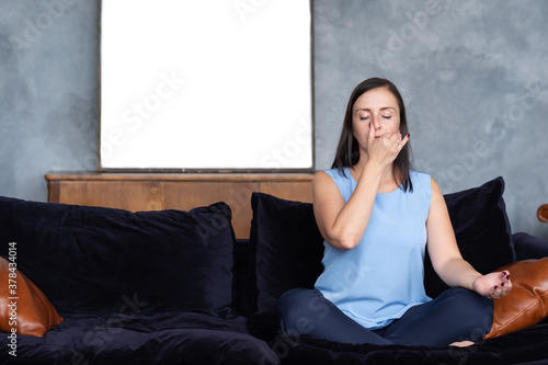 Healthy lifestyle concept. Young caucasian woman working out in living room breathing Pranayama