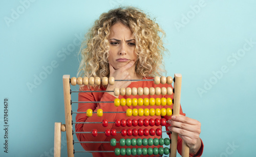 Girl with abacus is confused about the sum . cyan background