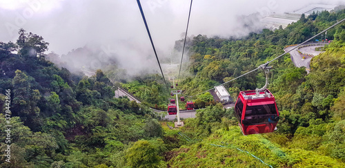 cable car at genting highlands, malaysia in a foggy weather with green grass visible from inside cable car