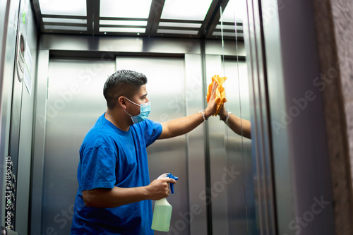 maintenance personnel disinfecting the interior of the elevator