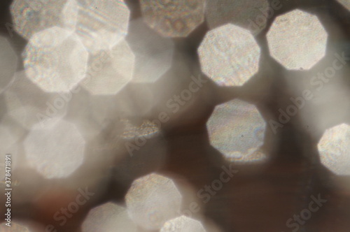 Background with a motif of fuzzy and rough water surface during rain with light reflections