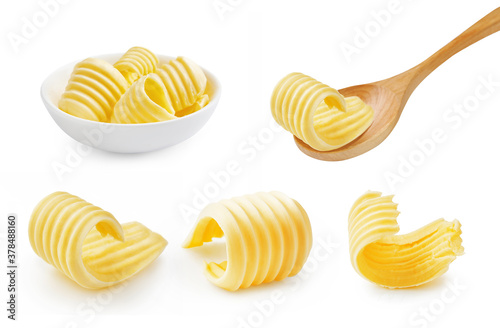 Set of butter curl on wooden spoon. Butter roll in white bowl isolated on white.