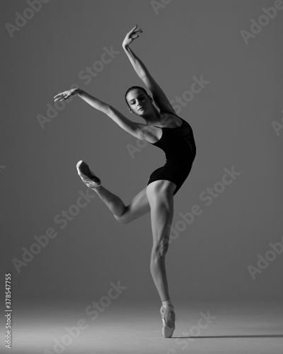 Young beautiful ballet dancer is posing in studio