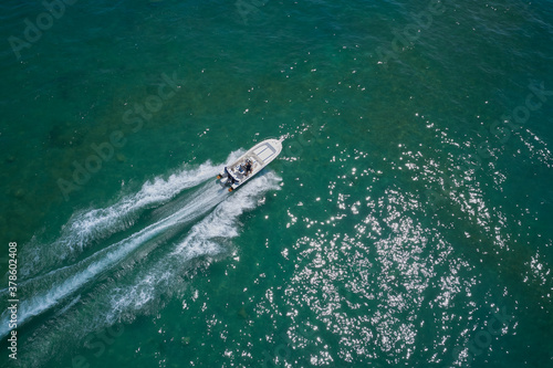 Drone view of a boat sailing. Top view of a white boat sailing to the blue sea. Motor boat in the sea. Travel - image.