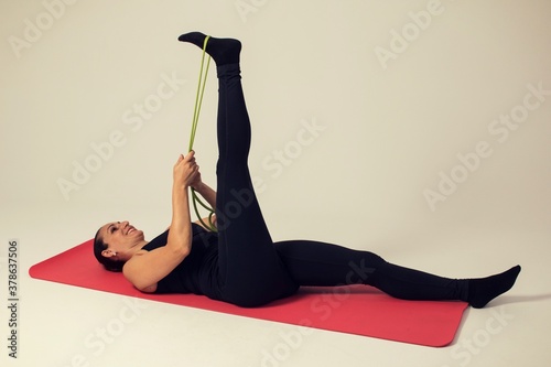 fitness woman with elastic bands doing hamstring stretch