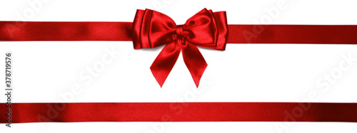 Red shiny bow with ribbons with long ribbon extending on both sides.