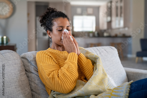 Cold sick african woman blowing nose