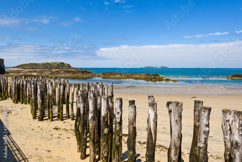 Wooden Poles on the beach at low tide in Saint Malo, Brittany, France
