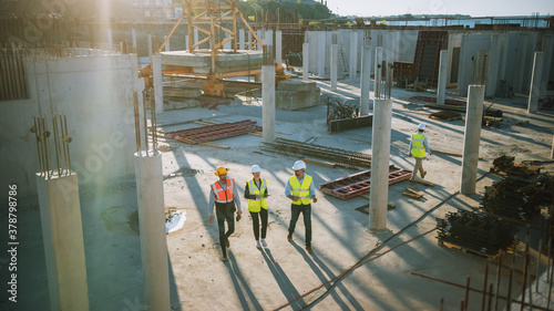 Diverse Team of Specialists Taking a Walk Through Construction Site. Real Estate Building Project with Senior Civil Engineer, Architect, General Worker Discussing Planning and Development Details.