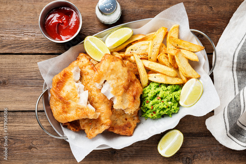 British Traditional Fish and chips with mashed peas and sauce.