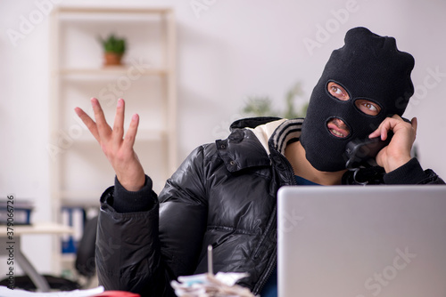 Young male burglar in the office