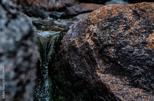 Close up of pure glacier water running through a crack in the rocks down a stream.