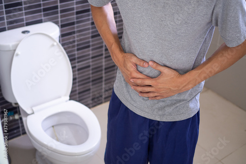 Man abdominal pain and constipation in the bathroom. Concept of health problems, stomach, diarrhea.