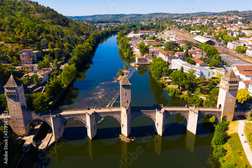 View from drone of medieval fortified arched Pont du Diable or Valentre bridge on river Lot in French town of Cahors in summer