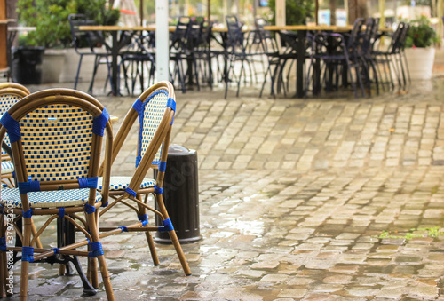 Empty terrace of the restaurant after the rain, wet wooden chairs and tables on the street of Barcelona, Spain