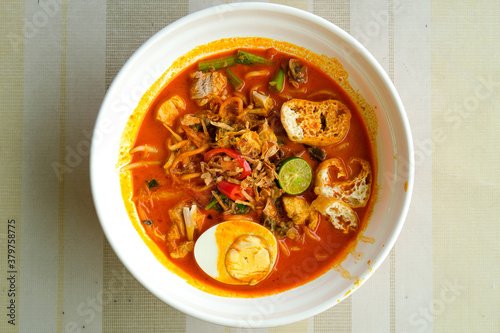 Flatlay picture of Nusantara cuisine called "curry laksa" on the table. Asian dish originated from the Maritime Southeast Asian community particularly in the region of Indonesia and Malaysia. 